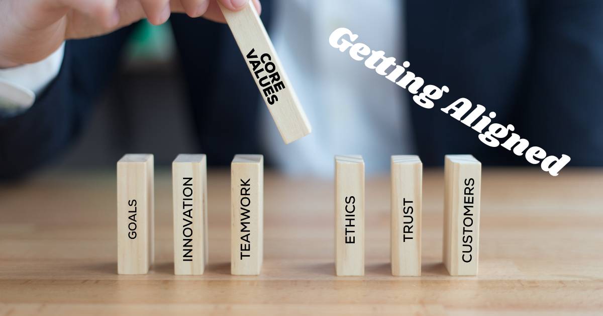 Person lining up blocks with words representing core values, like "goals, ethics, trust" etc.