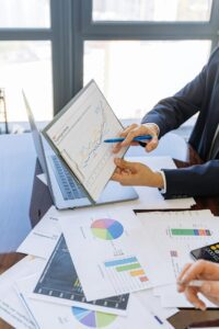 business risk management Two people looking over a table full of charts and graphs for analysis.