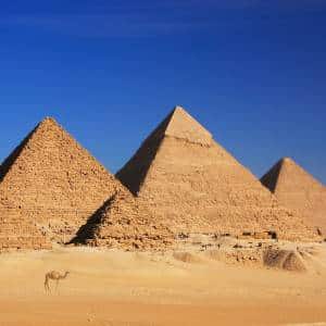 Pyramids of Giza with cloudless blue sky in background.