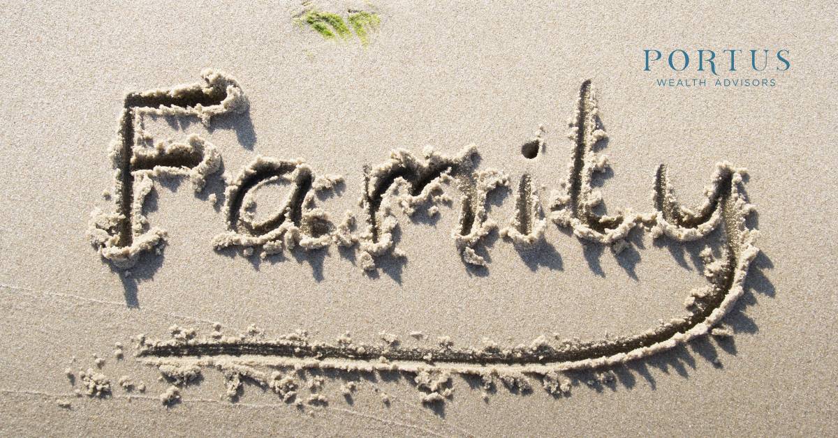 Image of the word "family" carved into the sand on a beach with the Portus Wealth Advisors logo in the top right corner.
