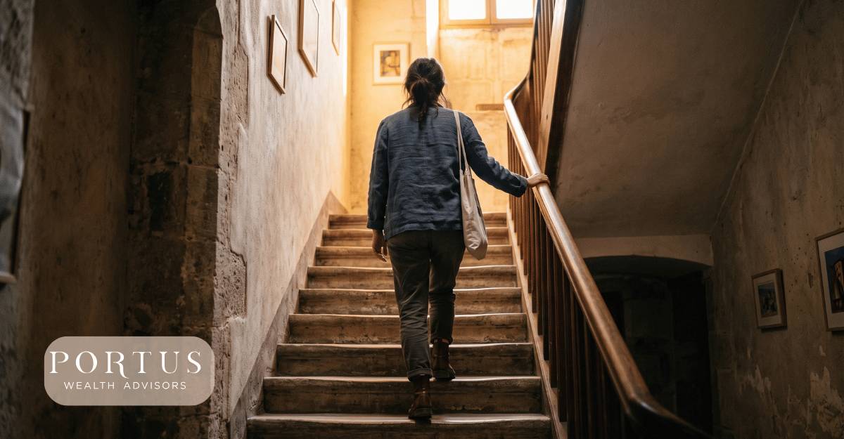 Image of awoman walking up a dark stairwell, with light emergeing and leadingg the way toward the top for the " Every Owner Is Already Doing Succession Planning" blog post